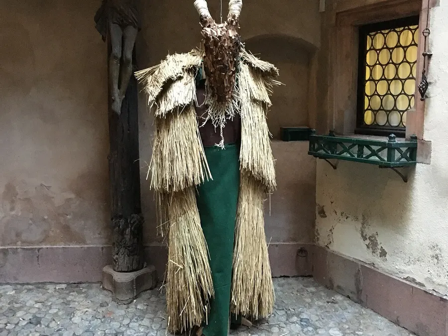 Figure de Hans Trapp, compagnon de saint Nicolas, en costume de paille avec des cornes au musée alsacien