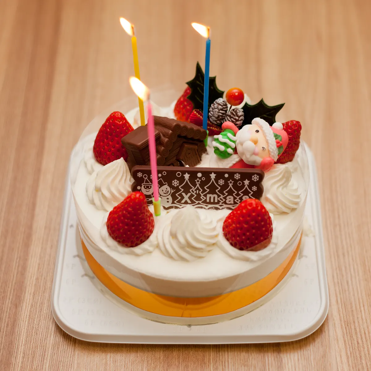 日本的聖誕蛋糕：白色鮮奶油、草莓、聖誕老人糖偶和巧克力牌