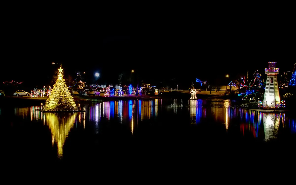 Lighted tree and lighthouse reflected in the water at the Simcoe Christmas Panorama of Lights