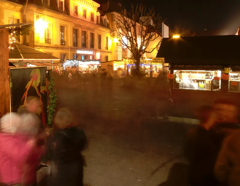 Foule devant les chalets du marché de Noël de Montbéliard le soir