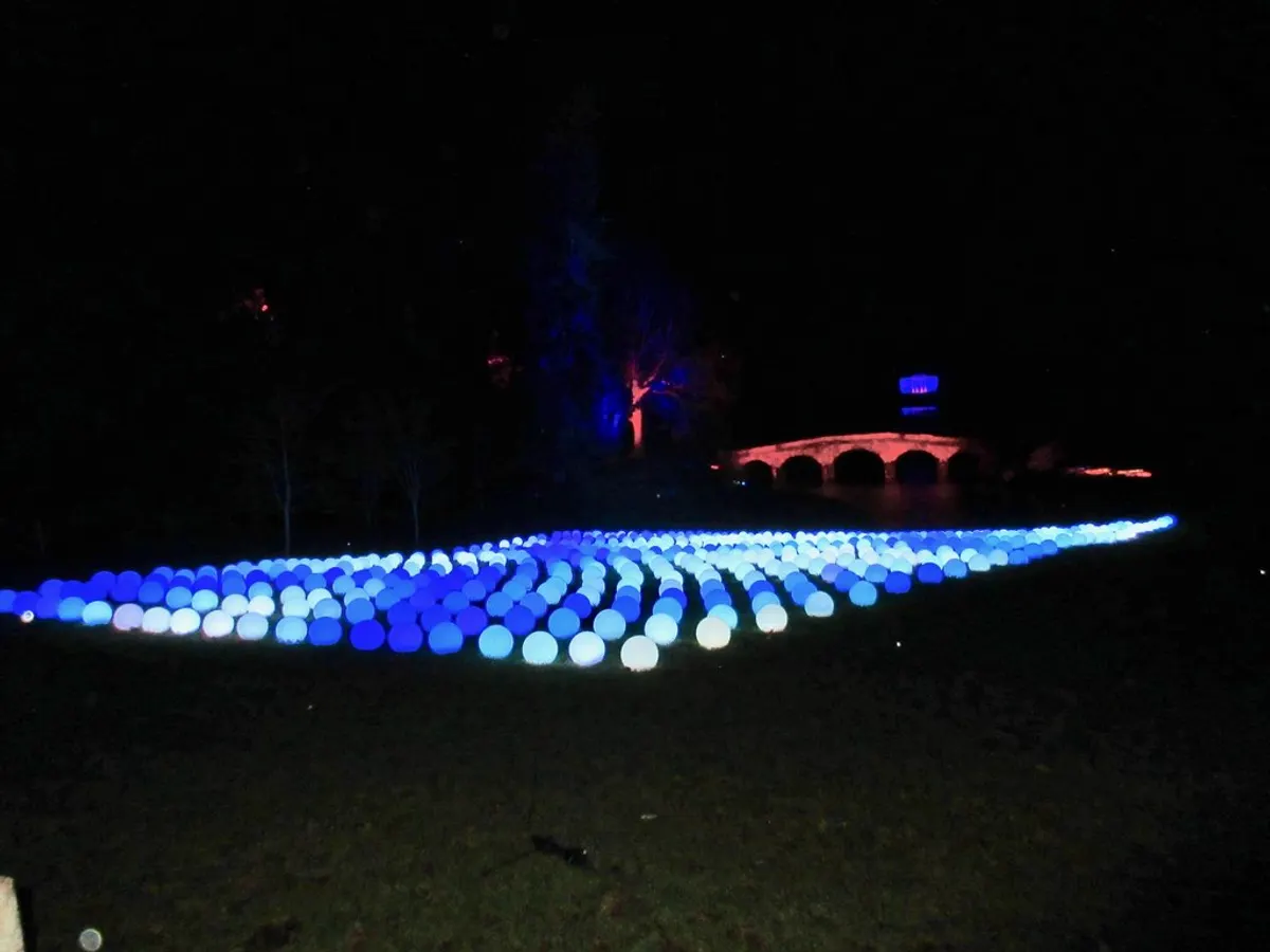 Blue glowing orbs laid across the lawn at Christmas at Stourhead