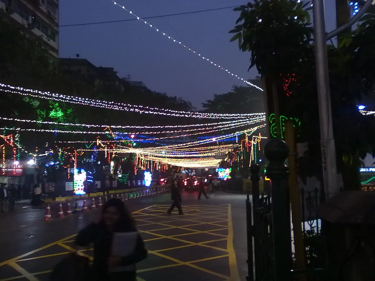 Strings of Christmas lights stretched across Park Street, Kolkata, at dusk