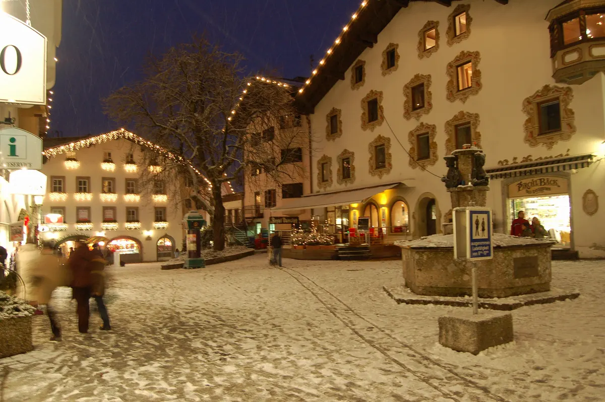 Verschneite Kitzbüheler Altstadt mit Lichterketten am Abend in der Adventszeit