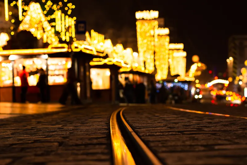 Lichterglanz über den Hütten am Linzer Hauptplatz mit Straßenbahngleisen