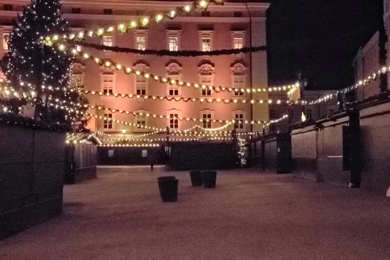 Lichterketten über den Hütten des Christkindlmarkts vor der Residenz in Salzburg