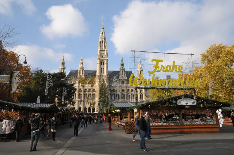 Marktgasse mit Hütten und Eingangsschild des Wiener Christkindlmarkts am Rathausplatz