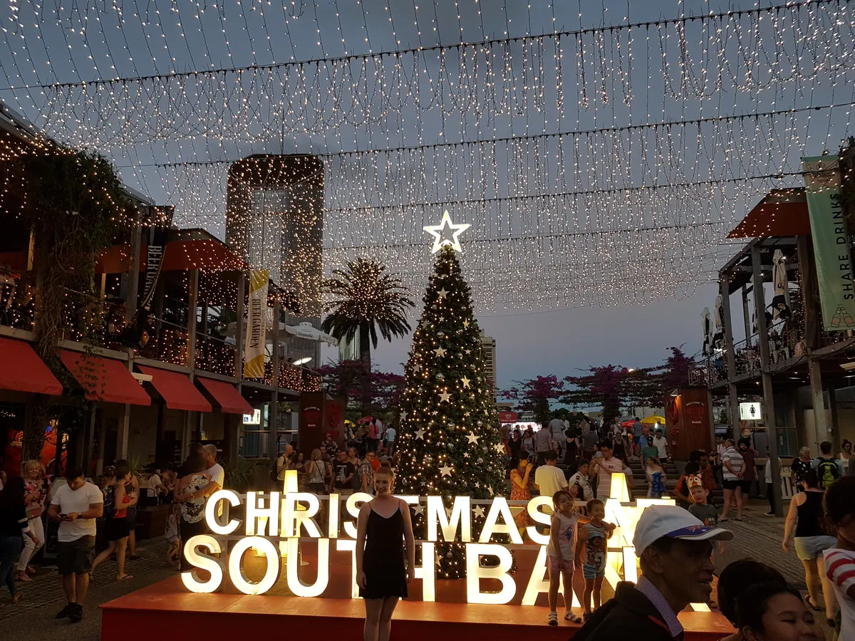 Christmas at South Bank sign and lit Christmas tree at dusk in Brisbane
