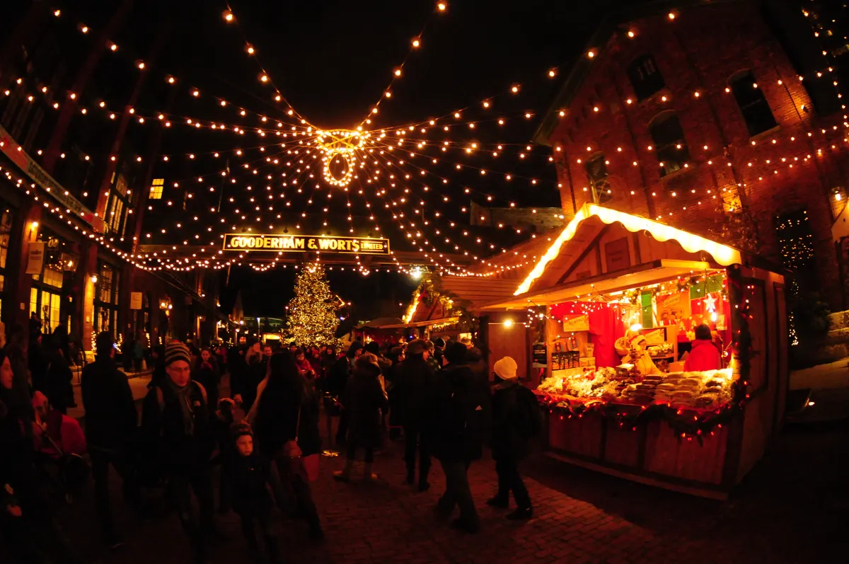 Wooden market stalls and strings of lights at the Toronto Christmas Market in the Distillery District