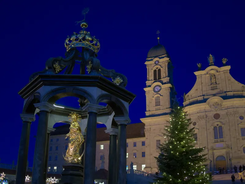 Marienbrunnen und Weihnachtsbaum vor dem Kloster Einsiedeln bei Nacht