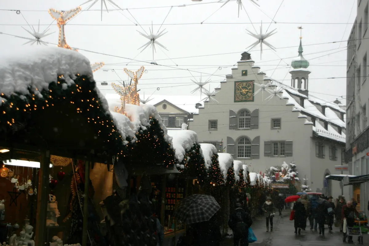 Verschneite Marktbuden und Sterne über der Gasse beim Sternenmarkt St. Gallen