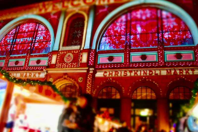 Farbig beleuchtete Fensterbögen über dem Christkindlimarkt im Hauptbahnhof Zürich