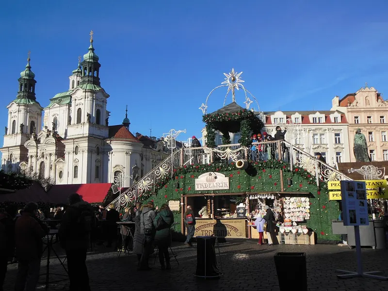 Stánky vánočních trhů na Staroměstském náměstí s kostelem sv. Mikuláše