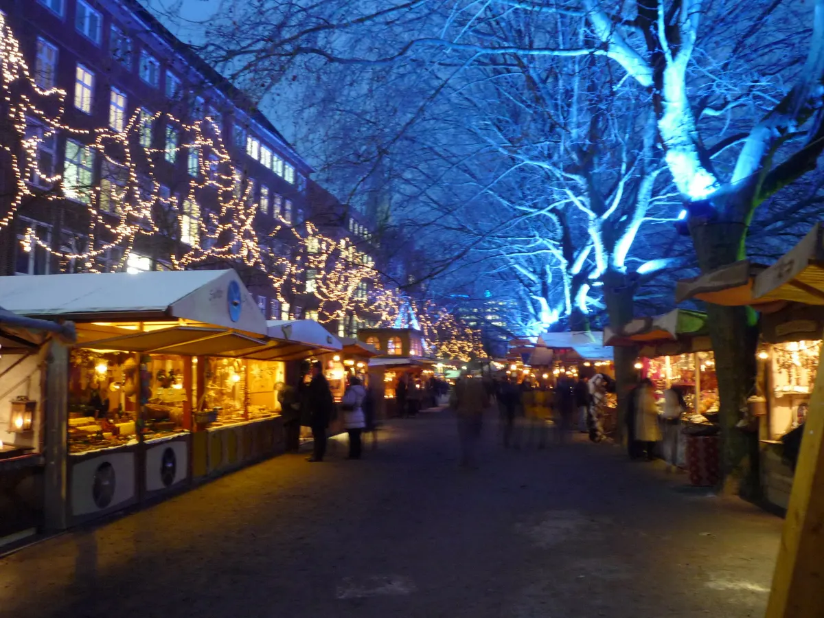 Blau beleuchtete Bäume und Marktbuden beim Schlachte-Zauber in Bremen