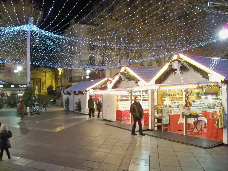 Chalets illuminés sous un ciel de lumières au marché de Noël d'Avignon