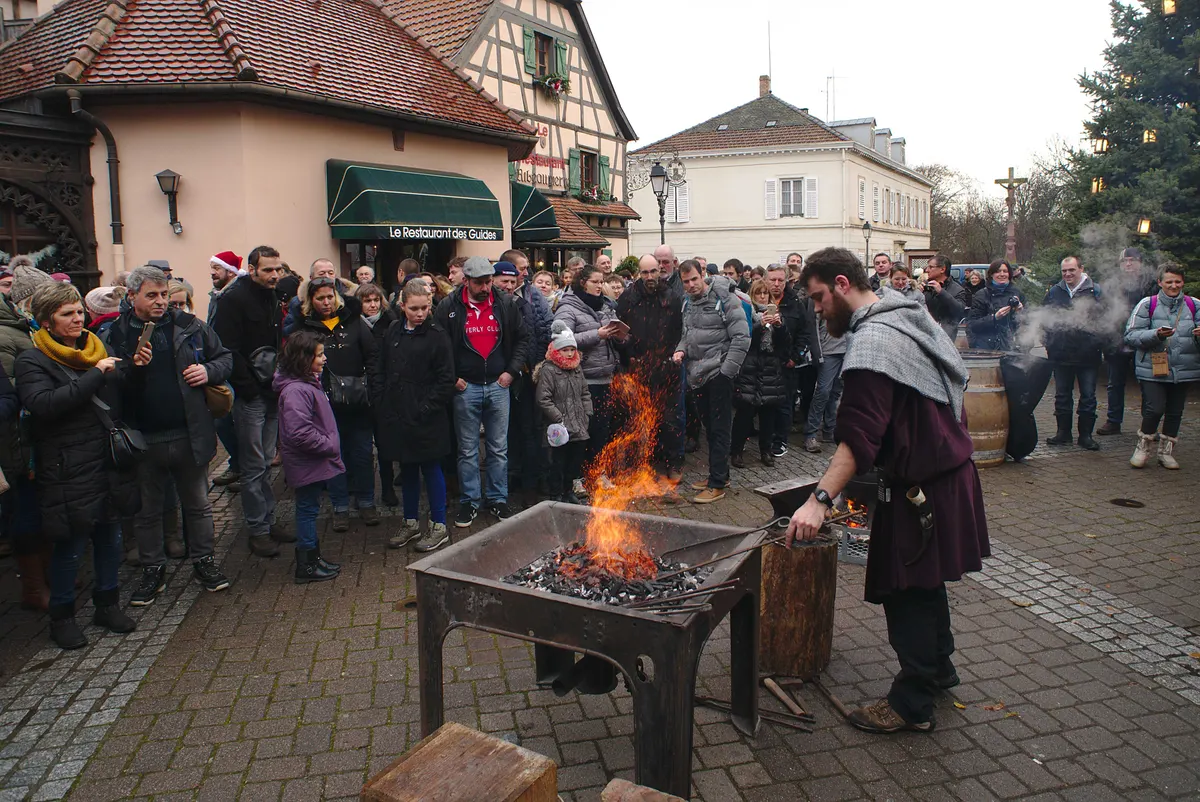 Forgeron en costume devant une foule au marché de Noël médiéval de Ribeauvillé