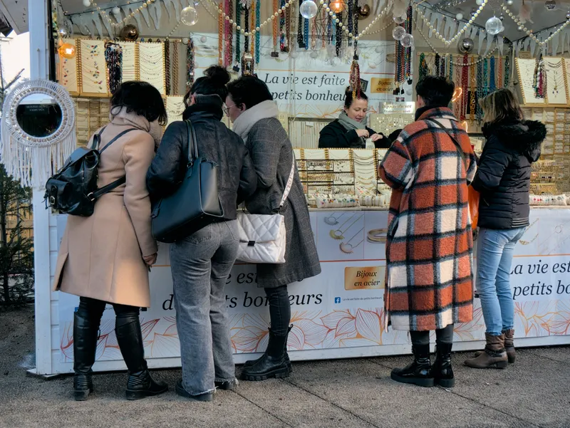 Clients devant un stand de bijoux au marché de Noël de Saint-Étienne