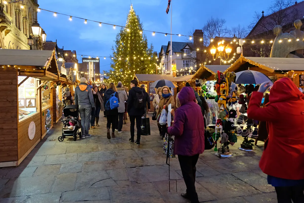 Chester Christmas Market stalls and tall Christmas tree at dusk