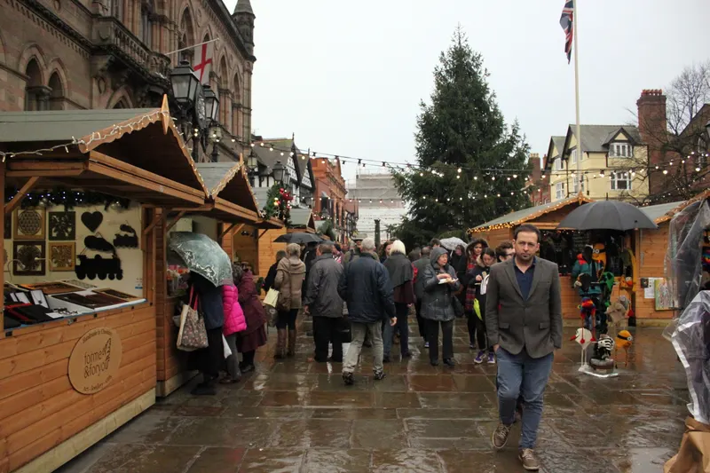 Shoppers at wooden stalls at Chester Christmas Market