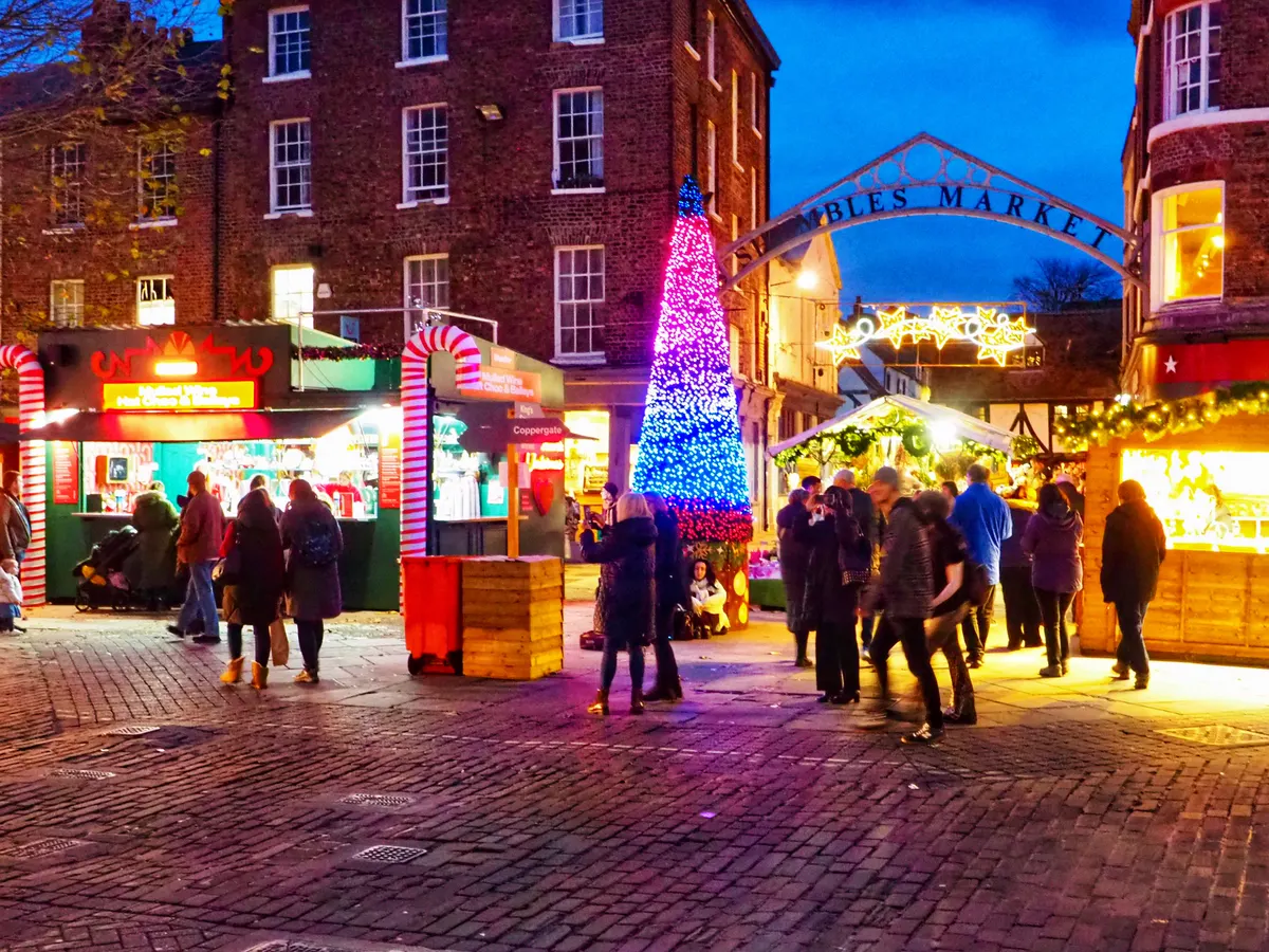 Illuminated stalls and Christmas tree at the entrance of York's St Nicholas Fair