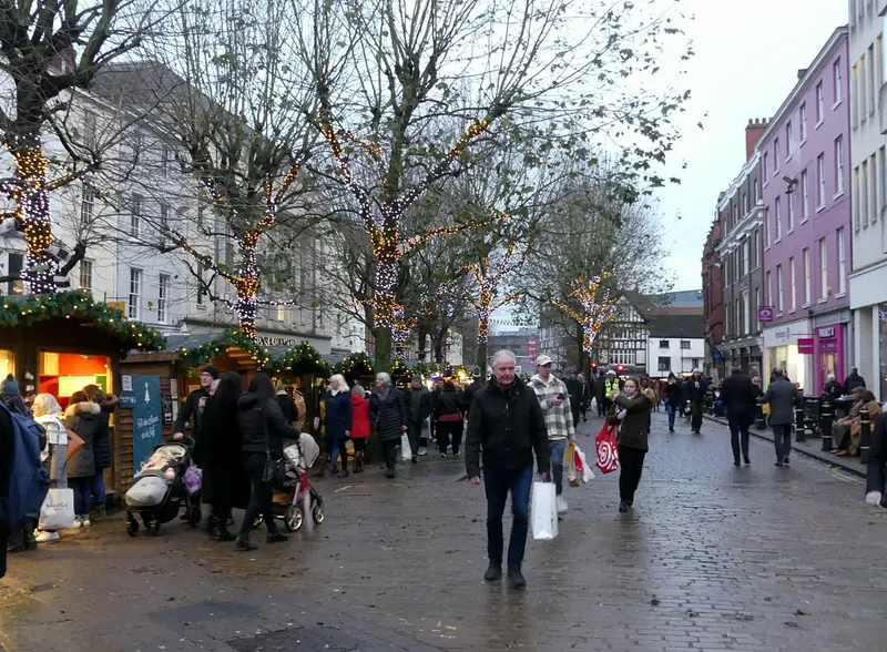 Shoppers on a York street lined with Christmas market stalls