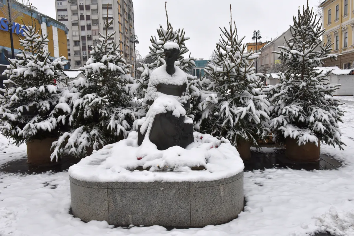 Snijegom prekriven kip i jelke na Trgu Ivane Brlić-Mažuranić u Slavonskom Brodu tijekom adventa
