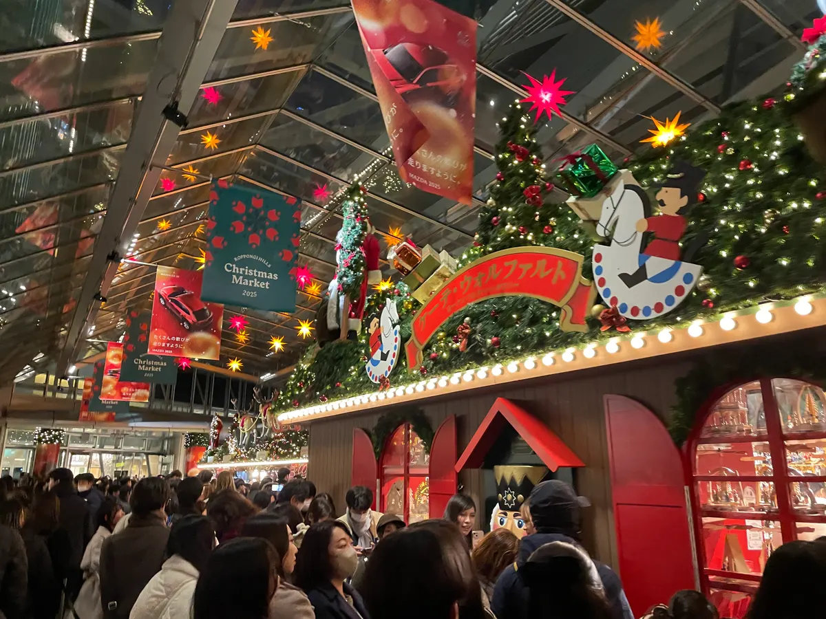 六本木ヒルズのクリスマスマーケット2025、赤い木組みの小屋と星のランタンの飾り