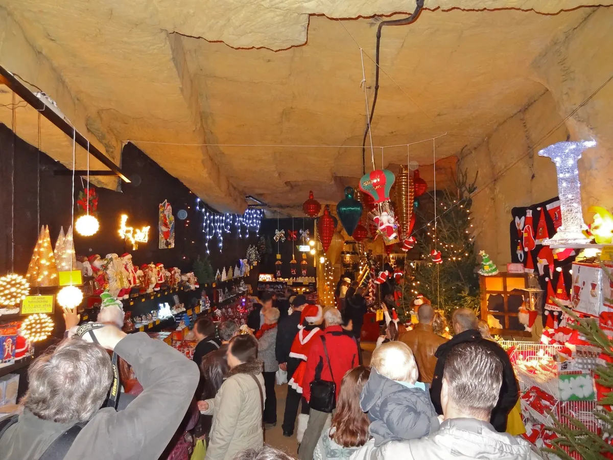 Kerstmarkt in de Fluweelengrot in Valkenburg met kramen vol kerstversiering onder het grotplafond