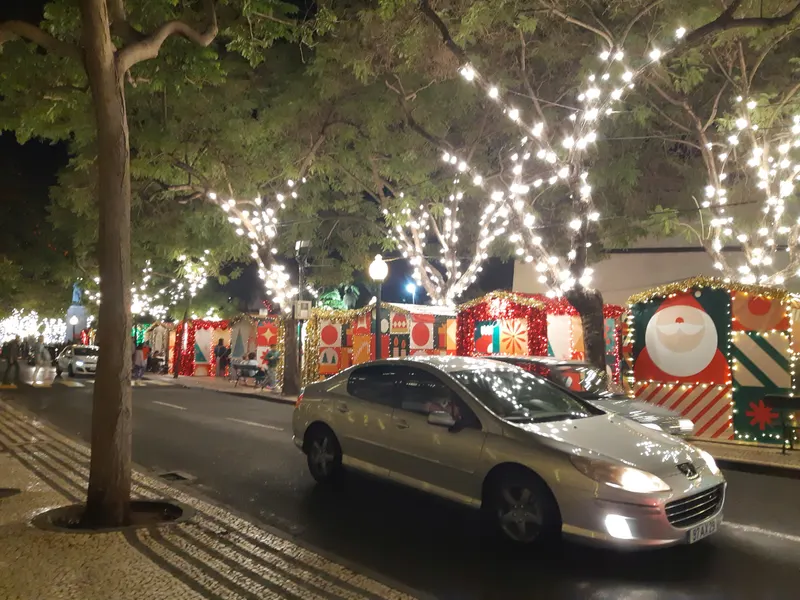 Casinhas do Mercado de Natal do Funchal à noite, com árvores iluminadas