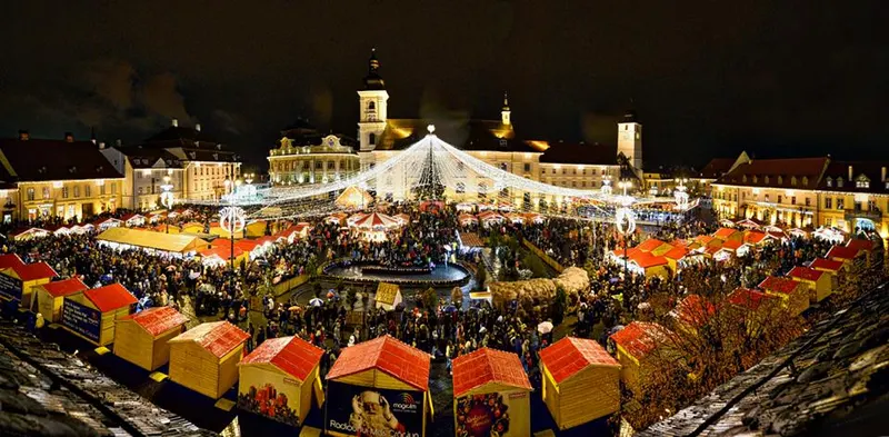 Căsuțele cu acoperiș roșu ale Târgului de Crăciun din Piața Mare din Sibiu, noaptea