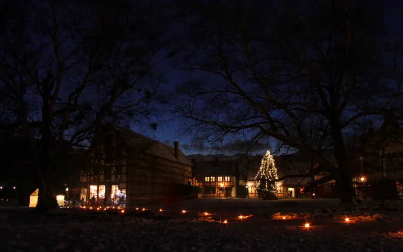 Fackverkshus och julgran i skymningen på Fredriksdal