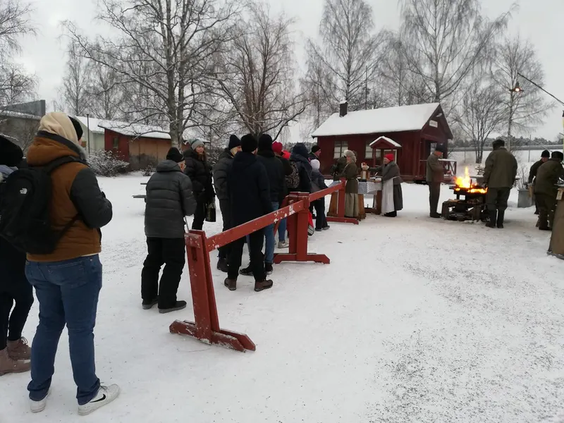 Besökare vid en eld på Jamtlis julmarknad