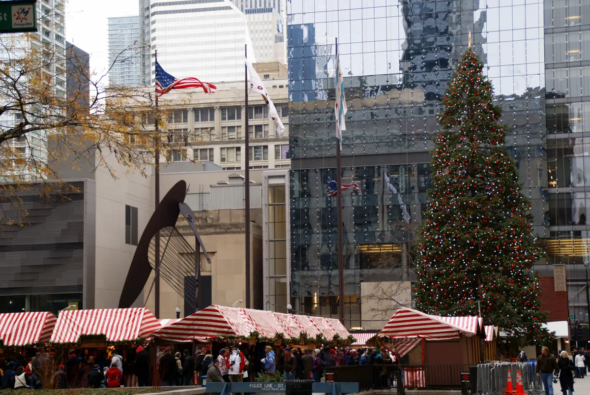 Red-and-white striped Christkindlmarket stalls and the Christmas tree on Daley Plaza in Chicago