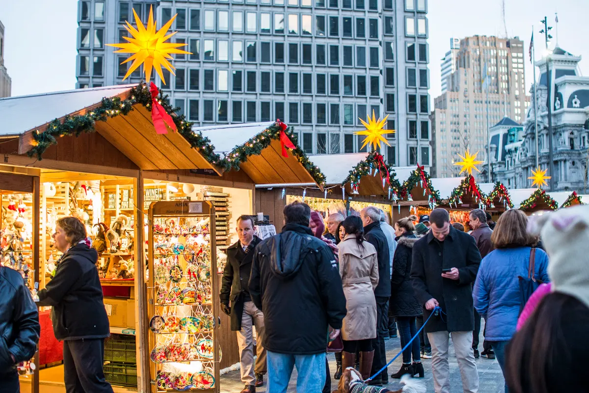 Shoppers at wooden stalls at Christmas Village in Philadelphia's LOVE Park