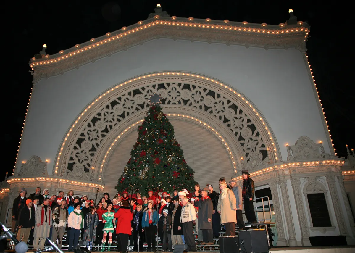 Choir in front of the lit Christmas tree at the Spreckels Organ Pavilion in Balboa Park during December Nights