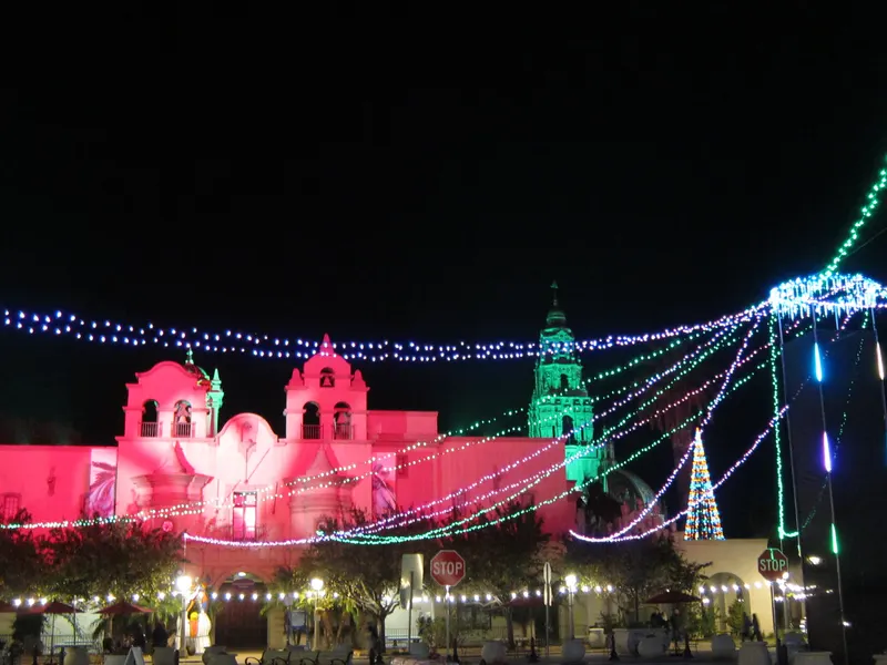 Balboa Park buildings lit with festive lights at night during December Nights