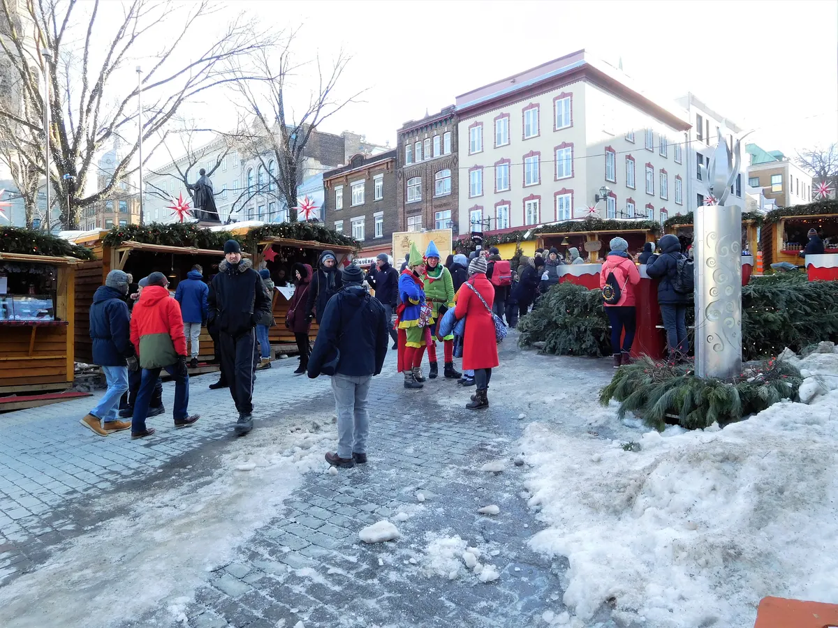 Chalets en bois et visiteurs au Marché de Noël allemand de Québec, place de l'Hôtel-de-Ville