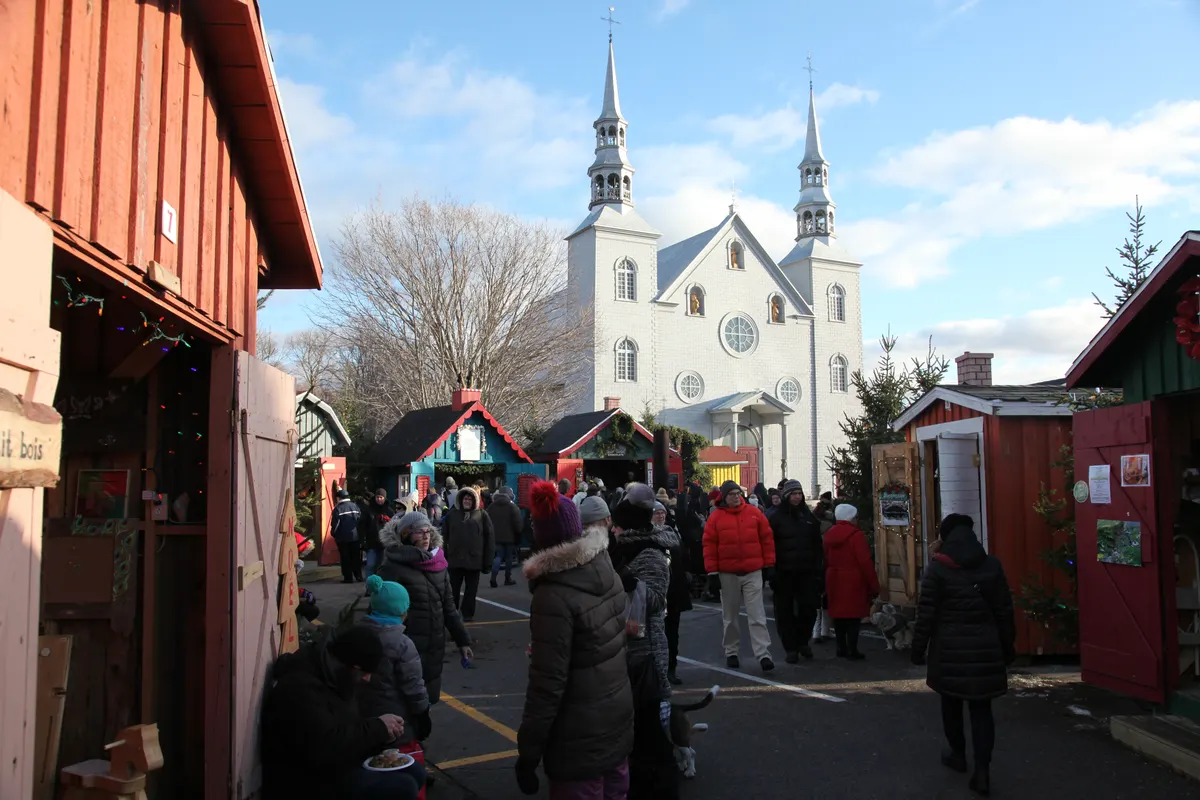 Visiteurs parmi les kiosques du Marché du Noël d'Antan, devant l'église de Cap-Santé