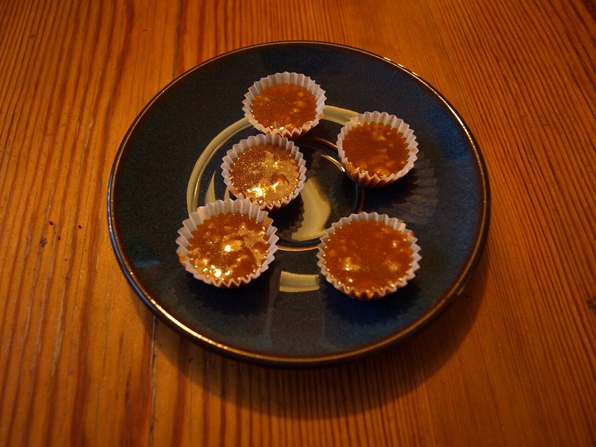 Fem knäck i vita pappersformar på ett fat