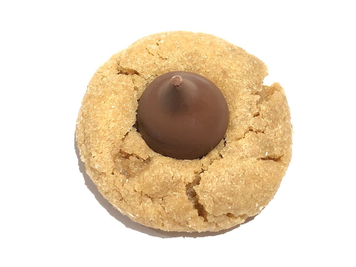 A peanut butter cookie with a chocolate kiss in the center